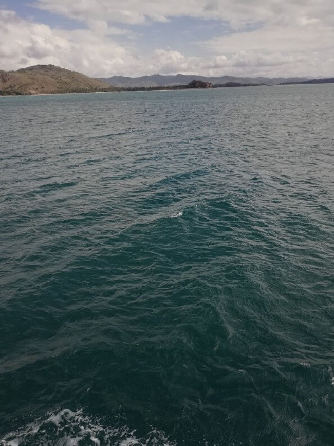 ロンボク島が近付いてきました。そろそろ到着する筈なのですが、沖に止まって動きません・・・<br />フェリーポートに先に停まっている船がいるらしく、その船が移動するまで入港できないみたいです(;・∀・)<br />1時間程待ってやっと入港できました。時間は16時、パダンバイからレンバーまで6時間弱かかりました。<br />下船後ツアー会社が待っており、バウチャーを渡し同じツアー会社を使用する人と一緒に少し待ちました。<br /><br />全員が揃った後このツアー会社の人が演説をはじめました。<br />あなたたちのツアーにはロンボクからギリへのパブリックボートのチケットが含まれています。ただ、フェリーの到着が遅すぎて、最後のパブリックボート（16時）にも間に合いません！明日の朝もう一度ここに来てくれればギリまで送ります。もし今から行きたいなら8人乗りの船を個別にチャーターしないといけない。これはツアー代金に含まれていないので、1人15万ルピア(約1200円)払えば乗せます。