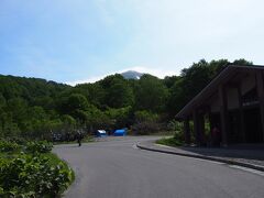 ９日
朝８時過ぎにキャンプ場を出発し、酸ヶ湯温泉近くの大駐車場にやってきました。
正面に八甲田大岳が見えますが、山頂は薄いガスに覆われています。

一瞬前回のトラウマがよみがえり、山頂ガスガスだったらいやだなぁと思いましたが日差しもあることですし、晴れることだろうと思い、出発しました。