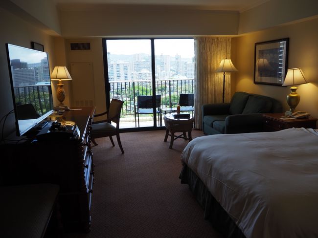 今回はCharley's Taxiで空港から宿泊先のHilton Hawaiian Villageまで。ホテルに着くと、運悪く部屋はまだ空いていないと言われ、Pre-checkinの手続きだけ済ませました。部屋の準備ができたら携帯にSMSを送ってあげると言われ、あまり期待しないで待っていたところ、30分も経たないうちにSMSがきました。やったーと思ってメールを読んでみると、（具体的な金額を忘れてしまいましたが確か）100ドルぐらい払うとアーリーチェックイン可能な部屋が準備できていると書かれており、寝不足でクタクタだった我々はまんまと彼らのビジネスに乗っかる形でチェックインしました。今回はKALIA TOWER9階の山側のお部屋で、バルコニーからダイアモンドヘッドが見えたのはラッキーでした！