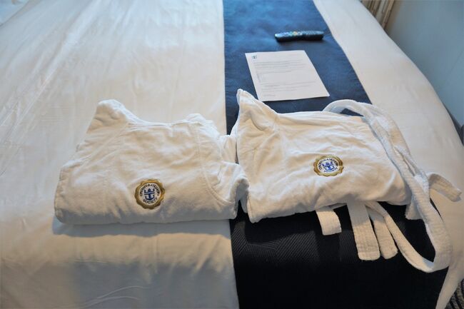 ジムで一汗かいて部屋に戻るとC&amp;A特典のバスローブが届いていました。<br />その上にあるのはボストン下船時間のリクエストシート。<br />ボストンでは米国再入国審査があるため、あらかじめリクエストを取って出来るだけその時間に沿った入国審査を受けられるようになっているようです。