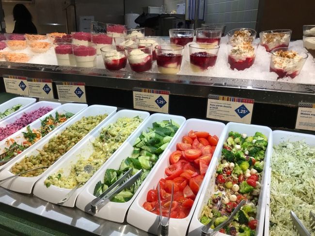 庶民的レストラン「リド」＠リガ<br /><br />またしても、スタローバヤ的セルフサービスのレストランへ。<br />旧市街の入口に近いこちらは店舗も広く、テイクアウト専用のカウンターもあったけど、地元で人気のお店なので、とにかく大賑わい。<br />一人だと会計を済ませてから席を探すしかないので、座れるのか心配したけど、なんとか席は見つけられた。<br />写真はサラダと冷たいデザートが並んだエリア。品数豊富すぎて決められない。