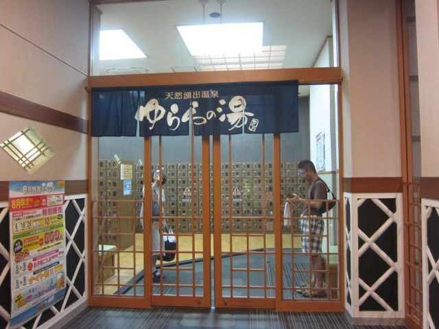 入口のドアです。奥に靴ロッカーがあります。ゆららの湯には大仏さんのようなキャラクターがいてあちこちに顔を出しています。