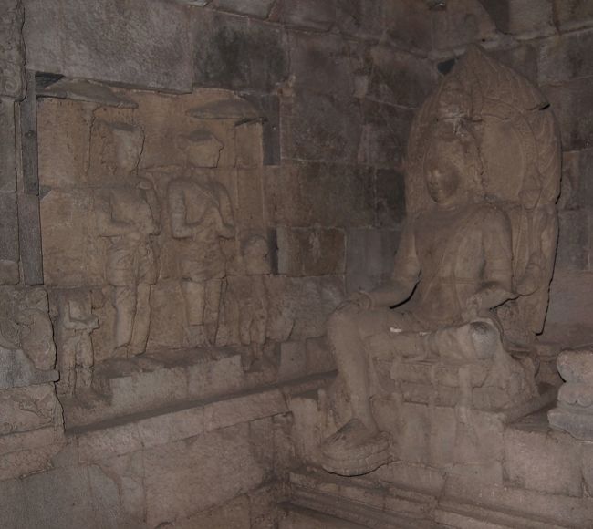 並んでいた左の石像には、隣の壁に手を合わせる人が彫られています。　手を合わせるので仏教と分かります。