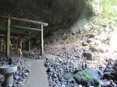 洞窟の中に鳥居と社があります。周りは石積みがいっぱいです。