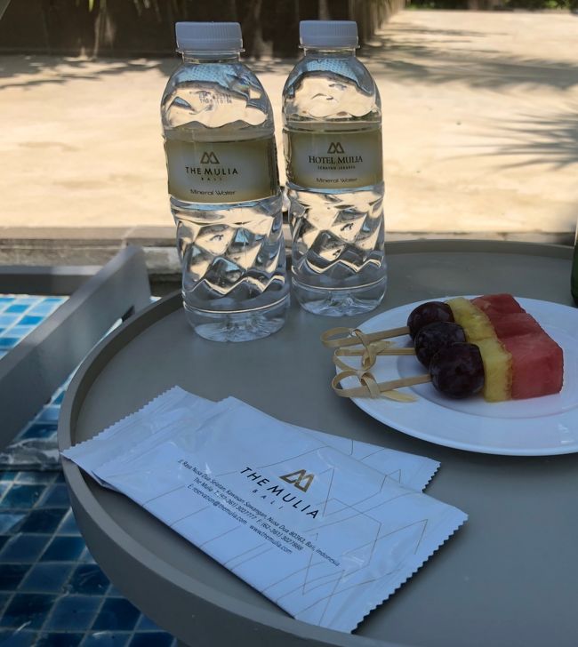 とりあえず、日差しは当たりますがプールの中にあるビーチチェアに決めました。スタッフがすぐにタオルをひいてセットしてくれます。ペットボトルのお水とウェットティシュも準備してくれました。奥にあるフルーツは、コンプリメタリーで配っていました。