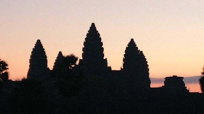 アンコール・ワットのサンライズを見るために、ＡＭ4：３０ホテルを出発。<br />暗い中アンコール・ワットに到着。係の人が懐中電灯でチケットを確認。<br />足元が見えなくつまずいたので、懐中電灯を持っている人の後ろを付いて行く。<br />太陽は遺跡の上には昇らなかったが、ゆっくりと静かに暗闇から赤くなって夜が明けていく。薄赤い空に遺跡が少しずつ浮かんでくるのが良かった。<br />周辺がドンドン明るく見え始め、2日目スタート。<br /><br />春分の日と秋分の日の近い日は遺跡の上に太陽が昇るようだ。