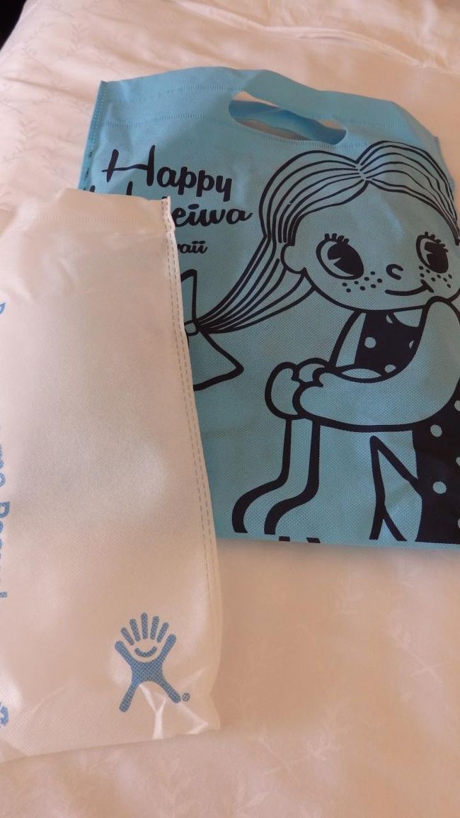 LeaLeaマーケットでハイドロフラスク買ったときに入れてくれた専用の袋と、ハッピーハレイワで買ったときに付けてもらった有料の袋。<br />ブルーの他に何種類も色があって、この袋を色違いで買っている人も見かけました。<br />安いし可愛いし、お土産入れて配ったりするのに良いかもね。