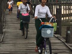 夕暮れ時のウーベイン橋を散歩していると向こうから女子学生たちが自転車に乗って帰宅中。みんなとってもかわいんです。こちらでは緑色の巻きスカート（ロンジー）が制服。