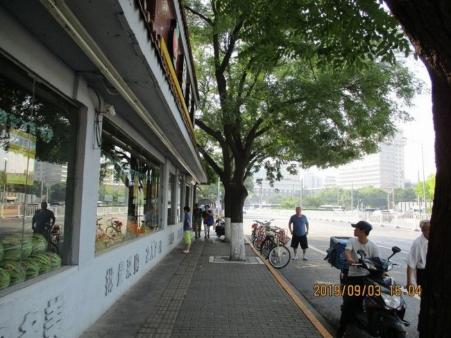 ■１日目：<br />北京午後３時。<br />　宿泊HOTELで荷ほどきののち外出。<br />　９月初旬の日差しは強いものの、砂漠（天安門から80kmの西方）からそう遠くないせいか、汗ばむようなことはない。<br />　芥川龍之介が北京滞在のおりに「・・・城外の広野を駱駝が走って居る有様などは何んとも言えない感が湧いて来ます」と語っていたらしいが・・・。<br />　さて、鉄道の北京駅からほど近い崇文門東大街。<br />　果物店の窓越に西瓜の山が目に入る。<br />　ひとびとの服装とあわせ、夏一色。<br />　（注：写真上の時刻は日本時間で、現地ではこれより１時間前。以下同様です。）