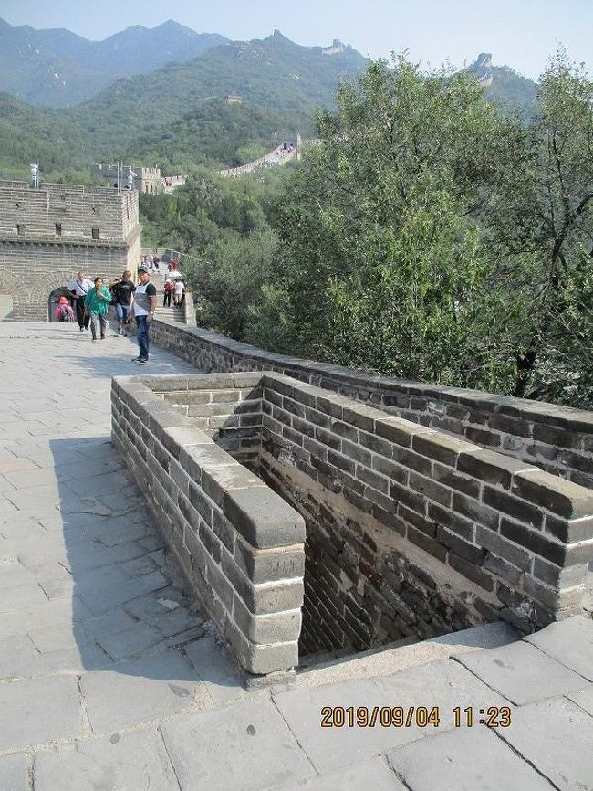 ↑ 城壁の上に到着。<br />　城壁を上に登り間近でみると、下からは見えなかった構造物も姿をみせる。<br />　写真の下へ降りる階段は、城壁の右、つまり北京側の下の道へ通じているようで、このほか城壁上を横断する溝も所々走っていた。<br />　画面の右上に向かっては、北コースの城壁が伸びていて、その上の観光客の、止まっているような歩く姿が遠景で望める。