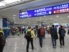 香港国際空港に到着。キャセイ航空２３３便に乗り換えます。（預けたスーツケースは、ミラノで受け取ります。）外国の空港でトランジットに不安を感じられる方が多いと思いますが、香港国際空港ではターミナルの主要な所に乗継ポイントがあるので、降機後は道なりに進み、このサインを探しましょう。このゲートでセキュリティチェックを受け、エスカレーターで出発フロアーに上がります。（この写真は帰りの時のものです。）
この時、香港市街地ではデモが随所で発生していましたが、空港は円滑に機能していました。