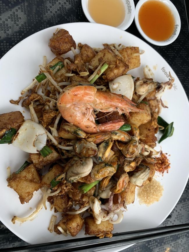 結局オーダーしたのがこちら Fried Radish Cake with Seafood 確か75バーツ。<br />色々なシーフードが入ってるのでこれに惹かれましたがこれ自体にあんまり味が付いていなくて、レジ前に色々なソースや砂糖や唐辛子が置いてあったのですがどれをどの分量足すのが美味しいのかよくわからないまま食べました。。