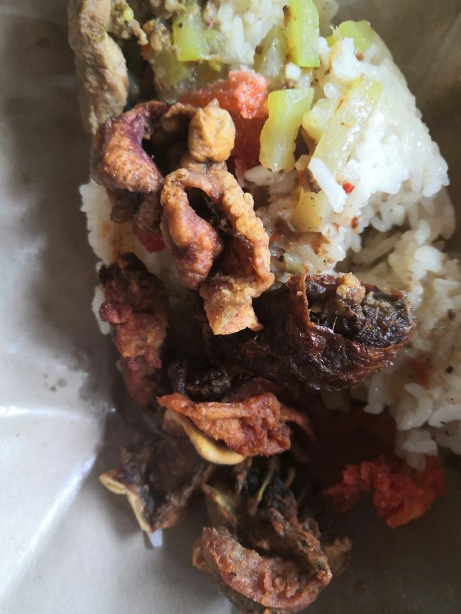 表紙のシンドゥ市場の前のワルン。<br />朝、８時になったらご飯が炊けるよ～<br />言われて買いに来たのが、このブンクス(*^-^*)<br />バビ（豚）アヤム（鶏）のおかずがたっぷり乗って、<br />さらにジューシィーな煮物野菜。<br />この盛りで15000Rp（約120円）<br /><br />えっ？これわ「おやつ」ではない・・・<br />いえいえ朝飯前の立派な「おやつ」ですよ(笑)。