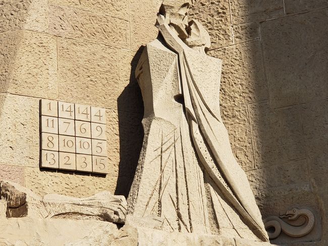 「サグラダファミリア」の裏部分、受難のファサード（門）の下部です。<br /><br />キリストに裏切り者のユダがキスをするところ。<br />これを合図にキリストは捕らえられることに！。<br />ユダの足元に蛇（裏切りの象徴）<br />左に魔法陣<br />（１－１５を使って縦横斜めの合計が３３という不吉な数字）<br />が見えます。<br />