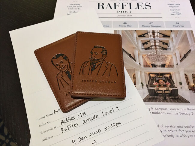 【 Palm Court Suite no.110 】<br /><br />CX635便で，香港からチャンギ空港に到着したのが2020年1月2日19時ジャスト。 ホテルの送迎車で19:43には，ラッフルズホテルに到着しました。<br />https://www.raffles.com/singapore/<br /><br />チェックインは客室で行われます。ジョゼフ・コンラッド（英国の小説家）とアンドレ・マルロー（フランスの作家，冒険家，政治家）のカードキーが渡されました。