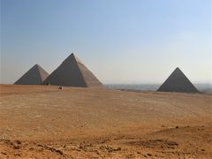 ギザの三大ピラミッドです。左からクフ王のピラミッド、カフラー王のピラミッド、メンカウラー王のピラミッドです。
ここから眺めるとカフラー王のピラミッドが一番高く見えますが、これはクフ王のピラミッドの基壇となる地面がカフラー王のピラミッドより低いためです。
ここではピラミッドを指でつまんだり手のひらの上に乗せたりと、トリック写真に挑戦しましたが写してくれた添乗員もガイドも写真の撮り方が下手くそ。
とても旅行記に掲載できるような写真ではありません。まだガイドの写真の方がましでしたが・・・。
具体的にはつまんだ指先とピラミッドの頂点との間に空間ができてたりとか、手のひらの上にピラミッドを乗せるはずが、手のひらの位置が地面にある時にシャッターを切っていたりとか最悪でした。
もう一度写真を撮ってもらうには再び順番を並ばないといけないので、私はもう2度目はパスしました。
ツアーの人数が多いのと、人によったら中国人のように何枚も写真を撮る様に要求するので遅々として順番が回って来ないのです。