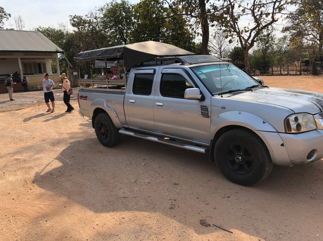 【14:30】プレアヴィヒア到着。<br /><br />正確には、麓の駐車場に到着。<br /><br />ここから山頂までは4WDで向かいます。<br /><br />確か６～７人乗りだったか・・・・３台に分かれて向かいます。<br /><br />ざっくり２～３人が４ＷＤの室内へ、そして残り４人くらいが荷台へ。<br /><br />こんなん、絶対、荷台のほうが楽しいだろ。<br /><br />ってことで荷台の争奪戦になるかと思いましたが笑、女性陣の多くは室内を希望したので平和に分かれました笑<br /><br />まあ室内のほうが冷房もあるし、快適と言えば快適でしょうが。<br /><br />絶対に荷台のほうが面白いと思いますよ笑<br />