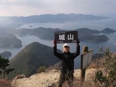 城山の山頂に到着です。どうも対馬は目的地付近になると急に案内が無くなるのです。先ほどの軍事施設のところが山頂かと思い、そのまま帰ってしまうところでした。

山頂の看板が固定されず置いてあるだけでしたので、それを持って登頂記念撮影です(^-^;