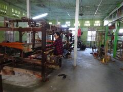 　ミャンマー最大規模の、マハーガンダーヨン僧院の食事風景までは少し時間があったので、伝統織物工房のシュエ・シン・タイ(観光客用の機屋)へ。
　アマラプラは、現在は織物産業が盛んで、集落を走っていると織物の音をよく耳にし、織物の機械をいじっている人をよく見かけます。