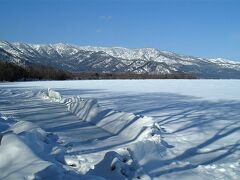 屈斜路湖の御神渡り　２月１８日
昼食に寄った屈斜路湖のはずれでは、御神渡りのように湖水が凍ってせりあがっていました。
「雄叫びの湖上を走る御神渡り　紅映」
寒気の深まりとともに屈斜路湖は凍りついて、つい２～３日前あたりから湖岸付近で小規模な御神渡り現象が見られるようになったそうです。写真手前が隆起した氷の列、遠方には美幌峠が見えます。 
地元の情報紙によると『2月16日に今年最長約４ｋｍの御神渡りを発見。立ち上がった氷の厚み５～１０ｃｍ最大高さ９０ｃｍ他小さいもの多数。湖中央部の氷の厚さ２０ｃｍ』
撮影場所：川湯温泉ホテルきたふくろうの自然塾付近の湖畔
