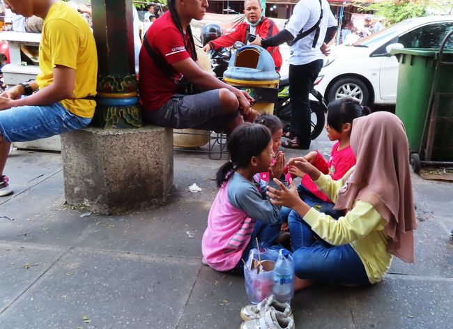 あらあら、靴ぬいで地べたにすわって遊んでる。