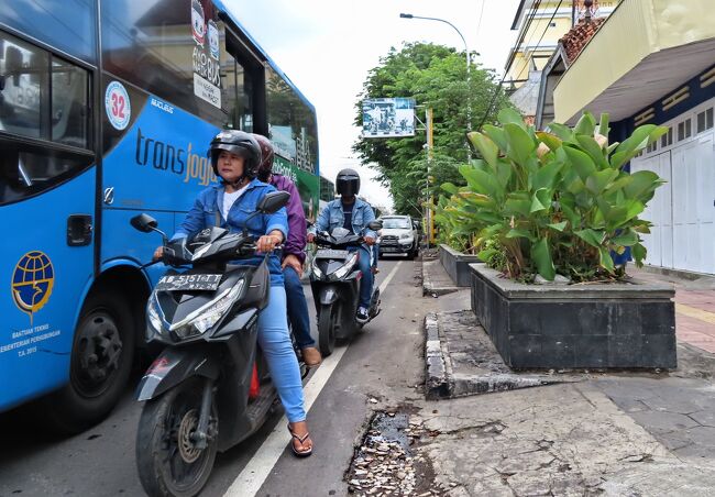 ホテルの前にたむろしているベチャで市場にいってみませう。<br />ベチャの運転手は観光客とみると<br />50,000ルピア（400円ほど）とふっかけてくるさうですが<br />私たちは二人とも白髪のせいかせいぜい25,000ルピアぐらいにしか<br />言われませぬ。<br /><br />この観光バスやオートバイで充満している道路をか弱いベチャで右折するのは至難の業のはずですが、ホテルの前にいるガードマンがすぐにやってきて交通整理のおまわりさんのやうにバスを止めてくれます。