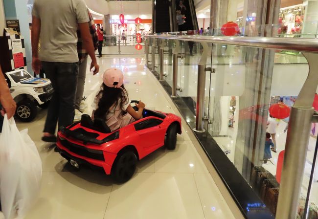 買い物客の通路を我が物顔におじょうちゃんの車が走る。<br />