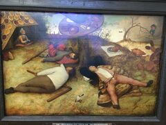 38枚目です。
The Land of Cockaige
Oil on Panel 52x78cm  1567
「怠け者たちの天国」

この絵はミュンヘンのアルテピナコテークにあります。(ブリューゲル（父）は2枚あります)

2015年12月にはこの「怠け者たちの天国」だけでした。

食べ物が置かれたテーブルの下には
右側にオレンジ色の服の学者
左側に白いシャツの農夫
奥には鎧と赤いマントの騎士
の怠け者が寝っ転がっています。