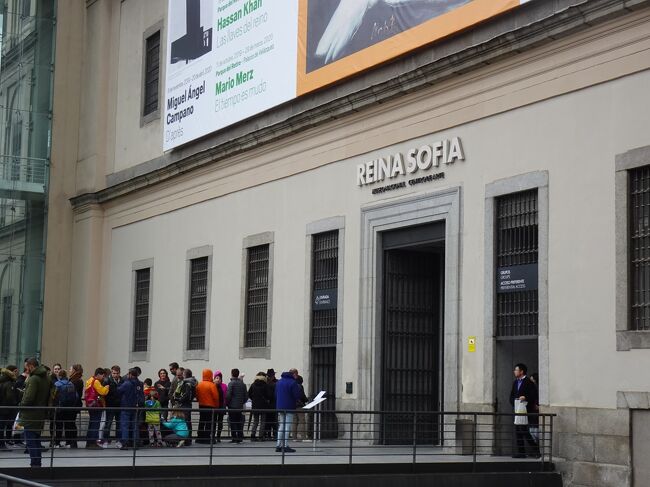 目的地のソフィア王妃芸術センター(レイナ・ソフィア)に到着です。<br />王宮からは徒歩30分くらいでした。<br /><br />実は、日曜13時半～19時と月・水・木・金・土19～21時は無料で入ることができます。この日は日曜日だったので、午後のオープンに合わせて並びに来ました。<br />同じ考えの人は多いようで、写真の通り行列ができています。