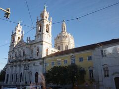 エストレーラ大聖堂（Basilica da Estrela）。
リスボンの西方の郊外にあるネオ・クラシック様式の大聖堂です。
１７６０年、ドナ・マリア１世（当時は王位継承者）は、
叔父であるペドロ３世と結婚し、翌年長男のジョゼが生まれました。
これを記念して建てられました。
内部はバロック調の装飾になっています。
１７７７年、ジョゼがドナ・マリアの妹と結婚した直後に
父であるジョゼ１世が死去し、
ドナ・マリア１世として即位します。
ジョゼ王太子は、天然痘で１７８８年に急逝します。
この頃からドナ・マリア１世は精神異常をきたし、
母・夫も相次いで亡くなったため、
完全に狂気の世界に入ってしまいました。
このため、３男のジョアンが摂政となりました。
１８０１年ナポレオンがスペインに進攻し、リスボンを占領しました。
ポルトガルは同盟を結んでいたイギリスの援助で
ブラジルに宮廷を移設します。
ドナ・マリア１世はブラジルのリオデジャネイロで、
１８１６年に亡くなりました。
その遺体はポルトガルが本国に戻った時に一緒に移され、
この大聖堂に埋葬されました。
ジョアン王太子はリオでジョアン６世として即位します。
イギリスが駐留していたポルトガルでは
「１８２０年自由主義革命」が起こって、イギリスが撤退し、
１８２２年にようやくジョアン６世は
ポルトガルに帰国することが出来ました。
この時ブラジルに摂政として残された王太子のドン・ペドロは、
１８２２年にブラジル帝国の独立宣言を行い、
ベドロ１世として即位します。
彼の息子ペドロ２世が１８３１年に即位し、
ブラジルの近代化に尽力します。
このブラジル帝国は、
１８８９年にクーデターにより共和国になりました。