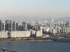2017年4月3日にグランドオープンした蚕室（チャムシル）にある
韓国で一番高い超高層ビル『ロッテワールドタワー』
（123階建て、高さ555ｍ）も見えます。

『ロッテワールドタワー』の76～101階に位置する世界で2番目に高い
ホテルは、5つ星ホテルの『シグニエルソウル（SIGNIEL SEOUL）』
で、最上階に位置する117～123階に展望台【ソウルスカイ
（SEOUL SKY）】があります。

『ロッテワールドタワー』がオープンした際に訪れた展望台
【ソウルスカイ】の旅行記は、こちらをご覧下さい↓

<アシアナ航空で行くソウル ⑦ 蚕室(チャムシル)★ 
トワイライトタイム＆夜景を狙って『ロッテワールドタワー』の
展望台「ソウルスカイ」に登ってきました♪ 
『ロッテワールドタワー』展望台割引き入場、チケット料金、予約、
混雑状況、持ち込み禁止物、アクセス、眺望などのご案内！ 
119F【キャラクターデザートカフェ】＆122F【ソウルスカイカフェ】
＆123Fプレミアムラウンジ【123ラウンジ】>

https://4travel.jp/travelogue/11313394