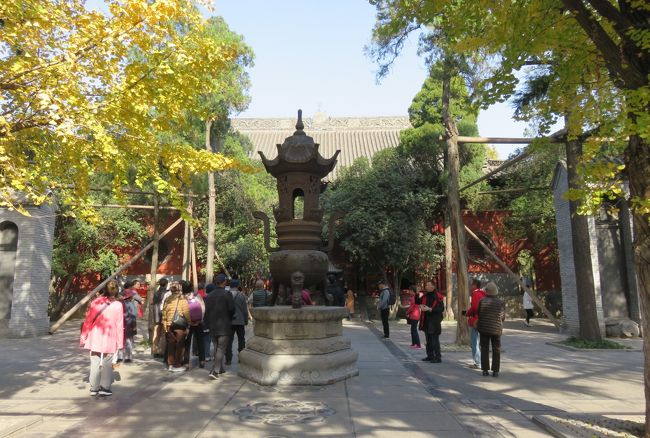 『天王殿』の次に向かったのは『大仏殿』です。その移動途中の光景です。参道の中央に建つ、大きな香炉の姿が見えてきました。周りにはプラタナスらしい黄葉の木々がありました。中国で経典の翻訳に従事した訳経僧で有名なのが、鳩摩羅什と玄奘三蔵です。平安時代の日本には、霊仙三蔵のような日本人の訳経僧もいました。