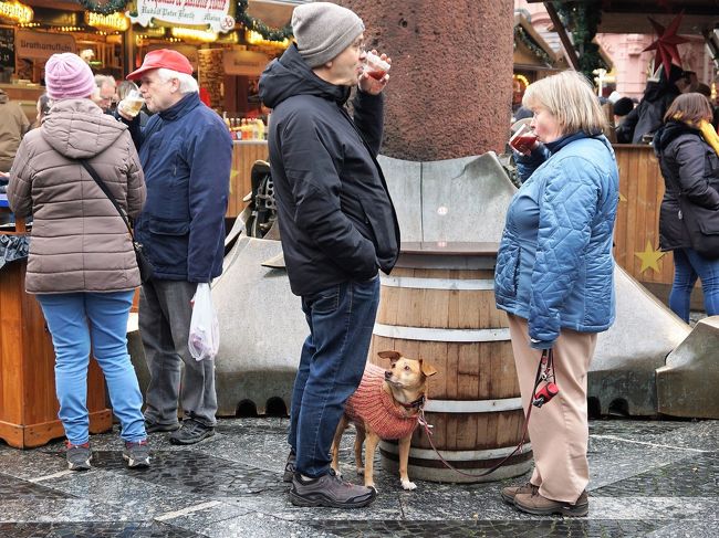 そのモニュメントの足元で、グリューヴァインを楽しむ人々。<br />ワンちゃん、「なに飲んでるの？味見したいなぁ」と訴えているようなまなざし？（^^）
