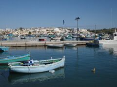 次に向かったのはマルサシュロックMarsaxlokk、マルタ島南東部にある漁港です。
レンタカーやタクシーであれば青の洞門から30分も掛からず出かけられるのですが、路線バスでとなるとそうはいきません。
大雑把に言えば島内のバス路線はほぼヴァレッタを中心に各地へ放射状に組まれているためヴァレッタ以外の観光地からヴァレッタ以外の観光地へ移動するには一度ヴァレッタを経由するようなイメージとなります。
この青の洞門からマルサシュロックへの移動も御多分に洩れず、ヴァレッタ郊外のバスストップでの乗換時間も含め所要約1時間半、トランスファーチケットを利用すればEUR1,50で済みますが決して効率が良いとは言えません。
マルサシュロック湾に奥まるこの漁港、とても温暖でむしろ暑いくらいでした。