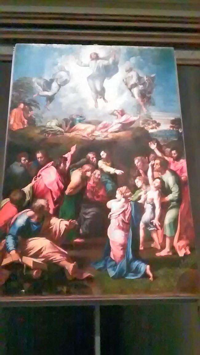 ラファエロ1520  「キリストの変容」ヴァチカン美術館<br />ラファエロの絶筆<br />＊福音書によると、イエス・キリストが、弟子たちを連れて、ある高い山にのぼったそうです。そして、その山の上で、予言者であるモーセやエリヤと語りながら、白く光り輝く姿を、弟子たちに示したという出来事です。<br />＊＊悪霊に取り憑かれた少年を治してもらおうと、イエスの弟子たちのもとに連れてきた父親。弟子たちは治療できず、イエスから信仰の薄い者たちよと諭される。<br />＊＊上下に二つの場面を設け、時間の経過を示す。<br />＊上半分を描いた時に、ラファエロは息を引き取った。37歳の若さ。描きかけの絵は、弟子が引き継ぎ見事に完成させた。上部の明、下部の暗が不調和だが、かえって、緊迫化と迫力を与えている。<br />＊＊これは、比類のない群像画の手本として影響を与え続けた。構図や人物ポーズは調和がとれていて、人物も硬直することなく空間の中で自由な感じが出ている。調和の群像画として評価されている。