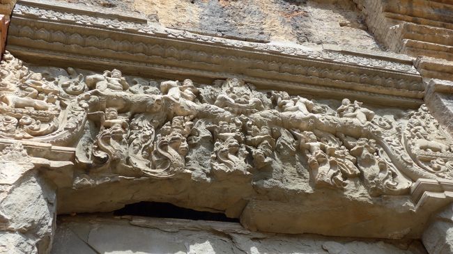 ６＜まぐさ石（リンテル）のレリーフ＞<br />これは、入り口上部の「まぐさ石」の魔除けのレリーフ。<br />神獣カーラに乗った神々や、ナーガに乗った戦士たちの躍動感ある姿が今も残る。しかし、触ればボロボロと剥落しそうだ。