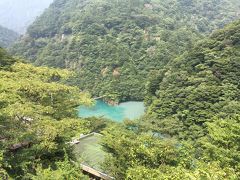 山々の間に覗くエメラルドグリーンの湖面と夢の吊り橋が見えてくる