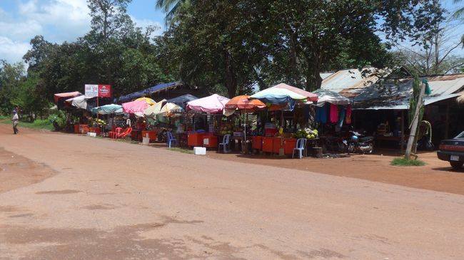 ３＜ベンメリアに到着＞<br />両側に木々が続く単調な道をひたすら進んでいくと、土産店や屋台が増えてきた。ここが目指すベンメリア。ロリュオスからは、約１時間半。<br />辺鄙な地と聞いていたが、結構観光客が来るようだ。<br />