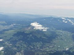 出発しました。右側に阿蘇山が見えました。山の上の大きな白いものは雲ですが、その左側に少し噴煙が見えます。