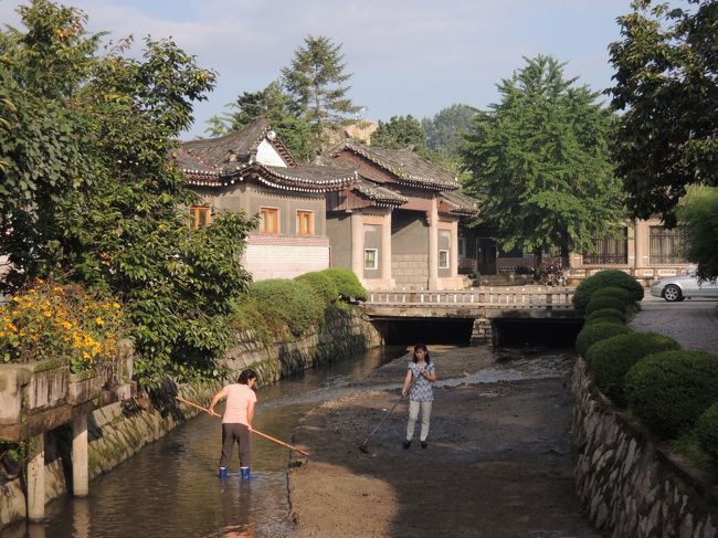 ホテルの敷地内を流れる川を掃除する人。