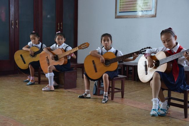 ギターの練習をする子供たち。