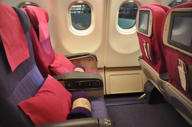 機内に乗り込み、席に着いた。しかしシートの様子が違うことに気づいた。<br />　シートピッチはかなり広くテーブルはすべて肘掛けに収納されている。エコノミーより豪華だがビジネスクラスに比べればしょぼい中途半端なシートだ。プレミアムエコノミーというのが全日空にあるがまさにあんな感じだ。リクライニングの角度はたいしたことないがレッグレストがついている。またコンセントもあるのでパソコンの充電も可能だ。