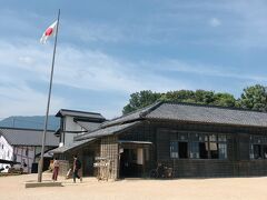 小学校校舎。　　青空にはためいている国旗を見上げるとまるで昭和初期にタイムスリップしたかのようです。