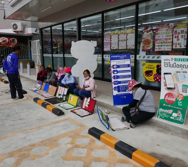 24日　セブンイレブン前で宝くじを売る人達．．．この時は6名だが多い日は10名ほどが並ぶ。