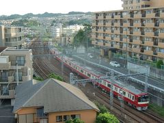 金沢八景駅の先で逗子・葉山駅方面が分岐する。東京都の密集地域に比べると緑が多く地形の変化があり恵まれた環境だが、それでも線路脇までかなり密集している。ましてや遠方に見える斜面の住宅街は凄まじい。