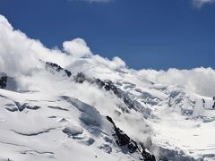 待つこと暫し。雲が流れて行き、モンブランの頂上全体が姿を現しました。
「やったー、モンブランが見えた。3度目の正直だ。」見えた瞬間は小躍りするほどに嬉しかった。時に2019年7月5日14時20分、忘れられない記念の日となりました。
35年前にエギーユ・デュ・ミディ展望台に上がった時は雲の中でしかも雪と氷の白一色の世界。コンデションが悪く周囲の山どころか何も見えませんでした。
もう一度来るぞと心に誓って33年後、今度はイタリアのエルブロンネ展望台に来たものの、モンブランの山頂は傘のように雲が張り付いて全く動こうとしなせんでした。モンブランには2度挑戦したものの山頂は見えず仕舞でした。。
2回目の時は周囲の山が見えていただけにとても残念な思いがしました。
そして今回、やっと念願が叶った。3回挑戦して良かった。

