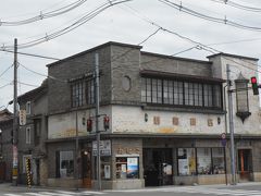 交差点の角にあったこちらの建物は若喜商店
創業260年の歴史ある味噌醤油を醸造販売するお店ですが、昭和6年に建てられた店舗は、土台にイタリアから輸入した大理石、壁のタイルは東京の帝国ホテルで採用された｢スクラッチス・タイル｣を貼った洋風建築。

