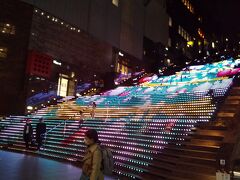 京都駅ビルの大階段には人が多くて、グラフィカルイルミネーションPlusというイルミネーションが点灯していました。
結構見応えある上に無料なのでガッツリ見ときます(笑)。
他にも京都タワー上ってみたい！とかもありつつ、明日のハードスケジュールを考えると早々にホテルに入るのが賢明。
次の行き先は烏丸御池、本日の宿泊先のホテルギンモンド京都です。
駅徒歩数分の駅近ホテルなので、見付けるの簡単です。
口コミサイトで結構得点が高いんだけど、なるほど私も高得点つけたくなるお宿でした。