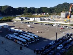 新宮港といっても最寄駅は紀勢線の新宮駅ではなく、紀伊佐野駅です。少し歩くと佐野松原という路線バスの停留場があり、新宮方面や那智勝浦方面に行くことができます。でも本数が少ないので、ここからの観光は船会社が用意したオプショナルツアーか、自力でタクシーを手配しての観光が現実的です。

下船が9:00予定で、でも一応余裕を見て9:30に下船するつもりでタクシーを手配しておきました。クリスタルタクシーという会社でしたが、まあホスピタリティに溢れるタクシー会社というか、すごく良かったです。運転手はもちろんですけど、港で交通整理というか客整理をしている内勤らしきスタッフの方もすごく印象が良かったです。商魂は当然あるんでしょうけど、それを表に出さず、せっかく新宮に来てくれたんだから楽しんで下さいね、というおもてなしの精神がすごく出ていました。強引な勧誘もなかったです。僕も見習わないといけないと思いました。

写真中央は船会社が手配した観光バス。行き先は勝浦駅周辺でのお買い物ツアー、熊野那智大社と滝ツアー、熊野本宮大社ツアーに分かれていました。
右側はタクシーの列です。船会社主催の貸切ツアー用タクシー、僕らのように自身で手配したタクシー、フリー（予約なし）で乗れるタクシーに分かれていました。
事前に調査したところ、この界隈にはさほどタクシー会社が多くなく、しかも保有台数は大きな会社でも20～30台程度のようでした。
飛鳥の乗船人員が半分になっているとはいえ、全てのタクシーが港に集結する訳でもないでしょうし、地域住民の足としても使われているでしょうし、そういうこともあって予約しておかないとタクシー待ちに巻き込まれてしまうと思って事前に配車の予約をしておきました。というのは10:00前に大門坂に着いて、そこから徒歩で熊野那智大社、青岸渡寺、那智の滝を観光し、那智の滝前からタクシーに乗って12:00には船に戻ってきたかったからです。フォーシーズンダイニングでの昼食は13:00までだったので、それに間に合うようにスケジュールを組みました。