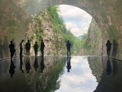清津峡渓谷トンネルの終点、パノラマステーションのインスタ映え水鏡。壁面がステンレスのため、外の景色が内部空間に映しこまれ、光のトンネルのようになる。水の向こう側には壁面に沿って、靴底を濡らしながら向かう。